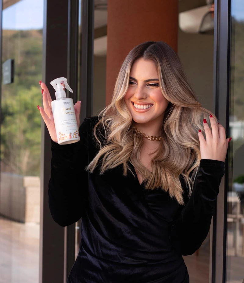 Modelo loira apresentando um produto Blond Vivance em post da DO•HA